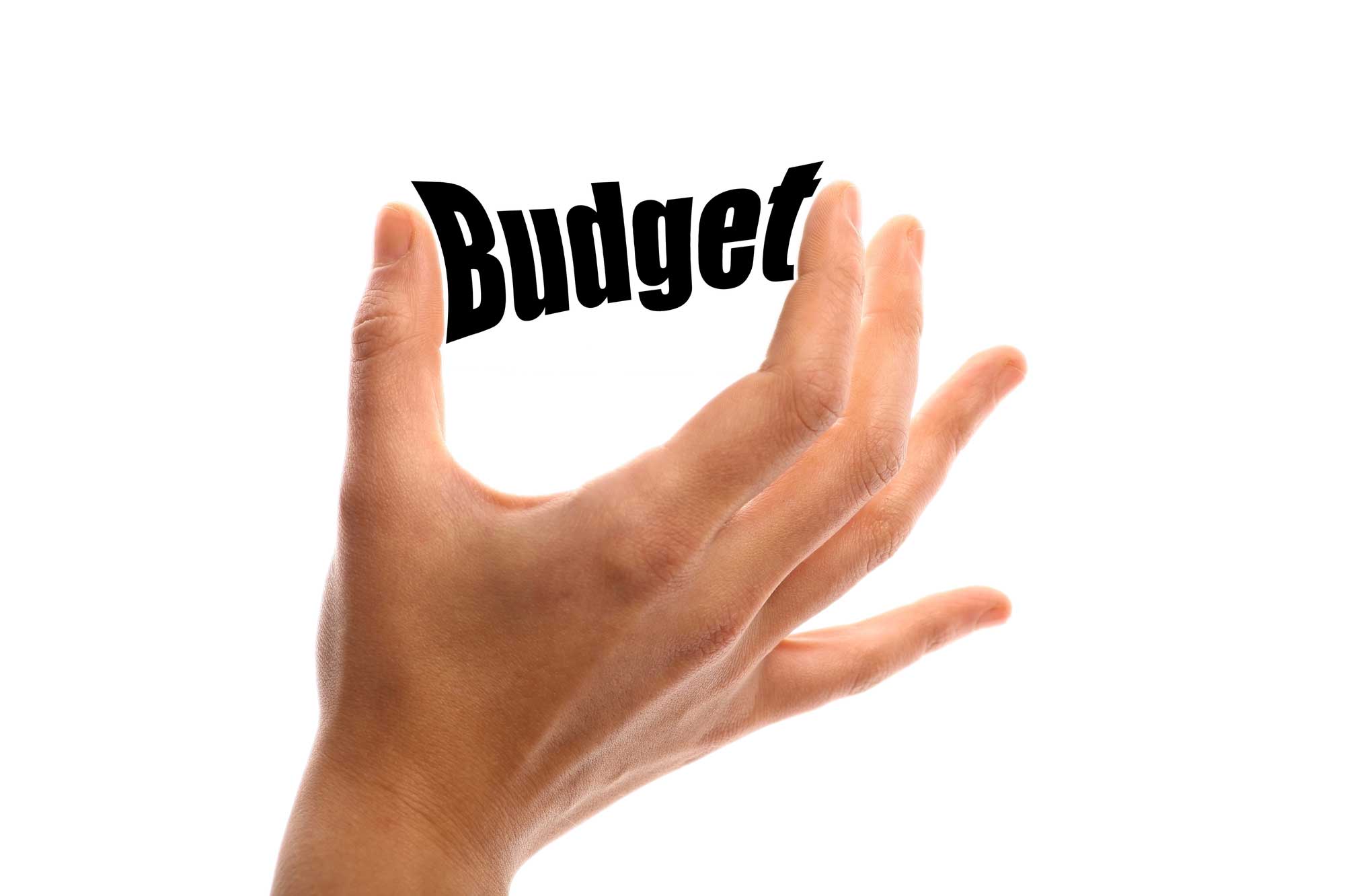 hand with fingers squeezing the word budget