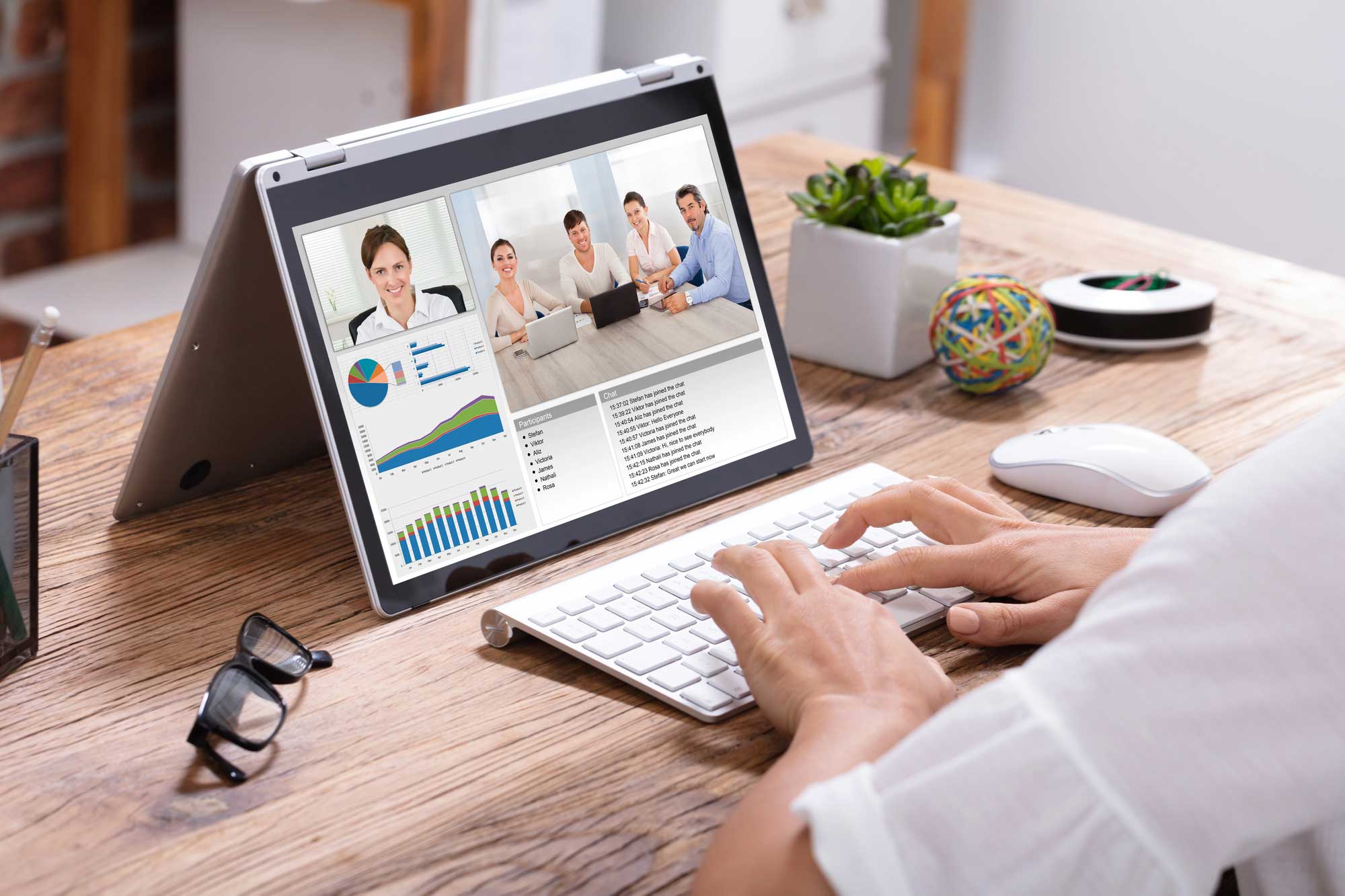 businesswoman video conferencing colleagues laptop wooden desk office